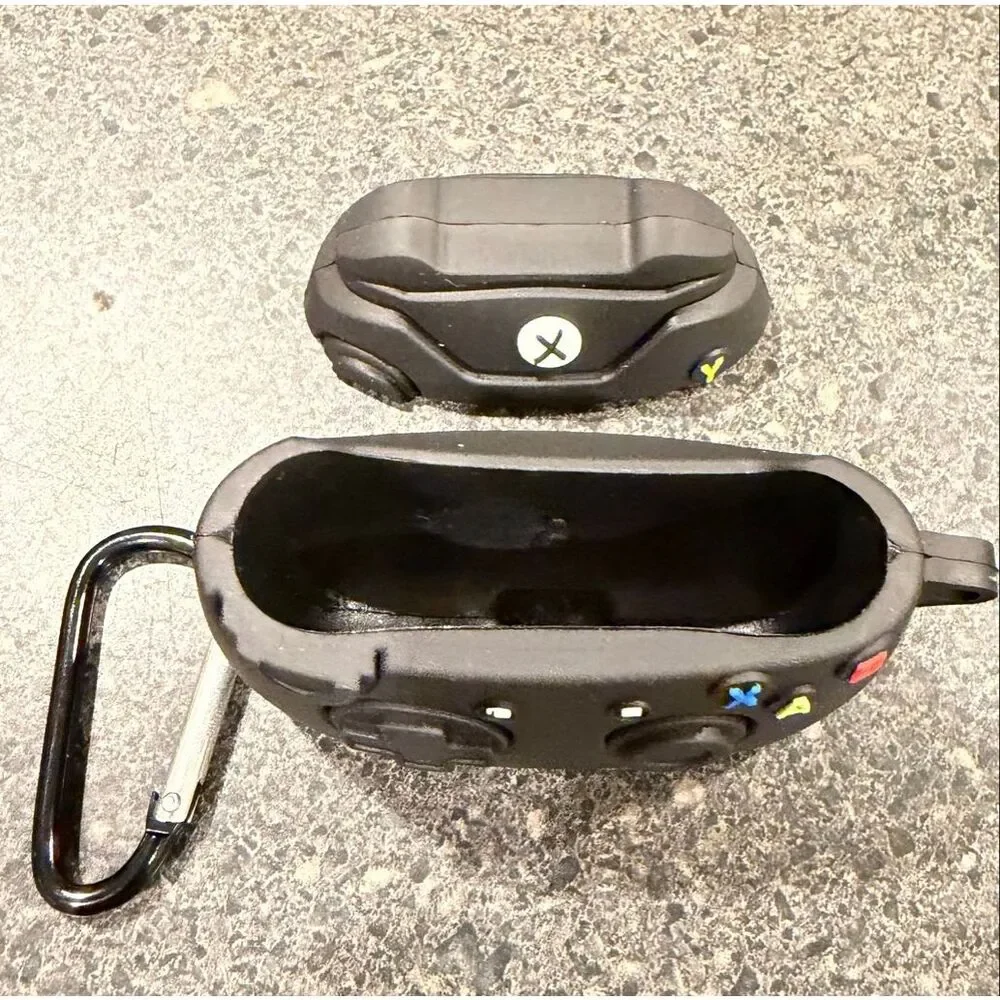 Silicone protective case for Apple AirPods, designed to resemble a black Xbox co